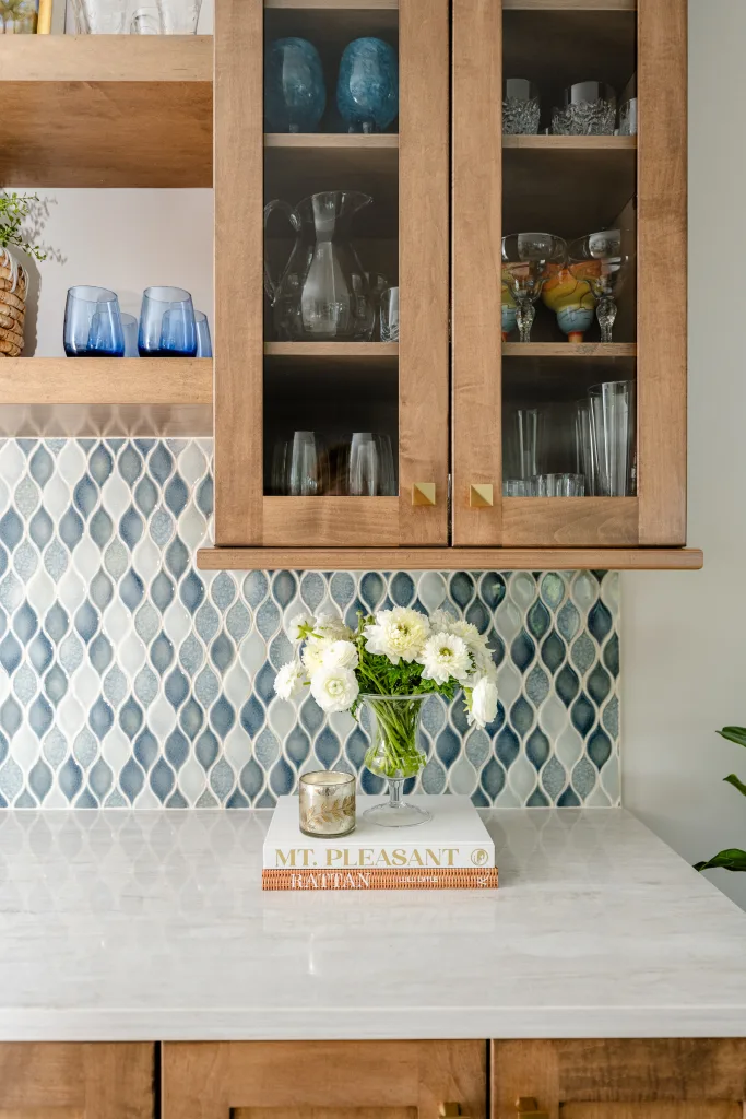 Counter vignette with blue glassware, white ranunculus, and book stack, Charleston, SC