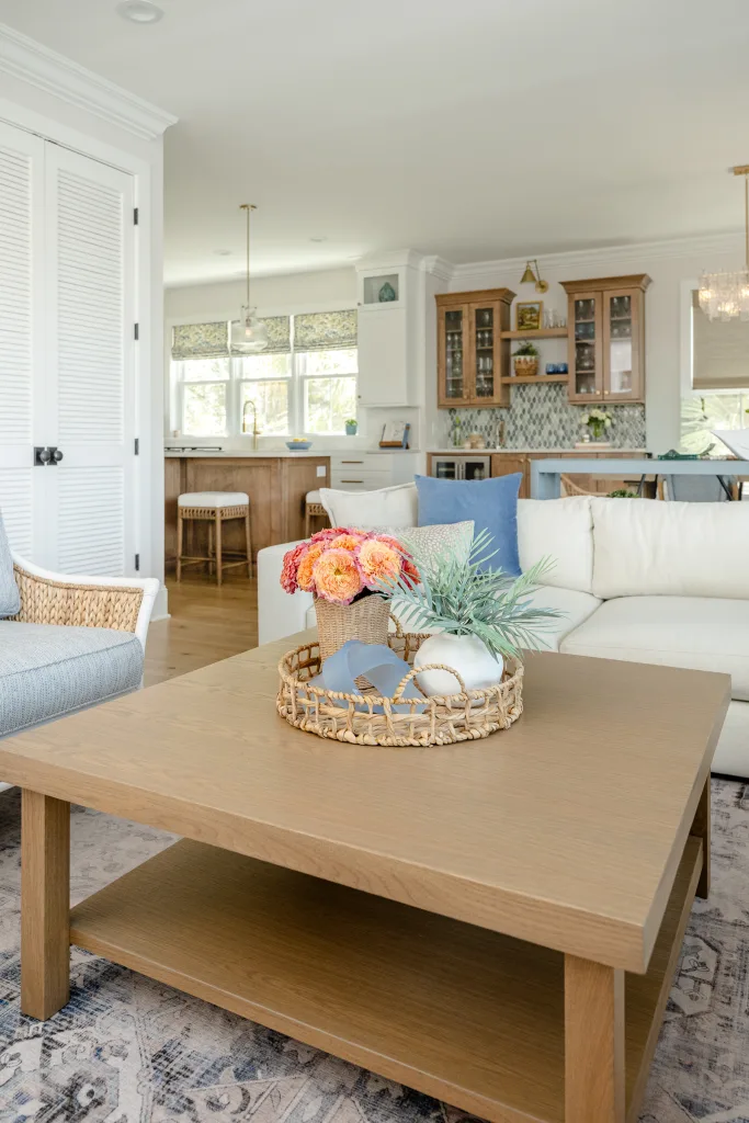 Coffee table styled with rattan tray, peonies, and shells in Charleston, SC living room