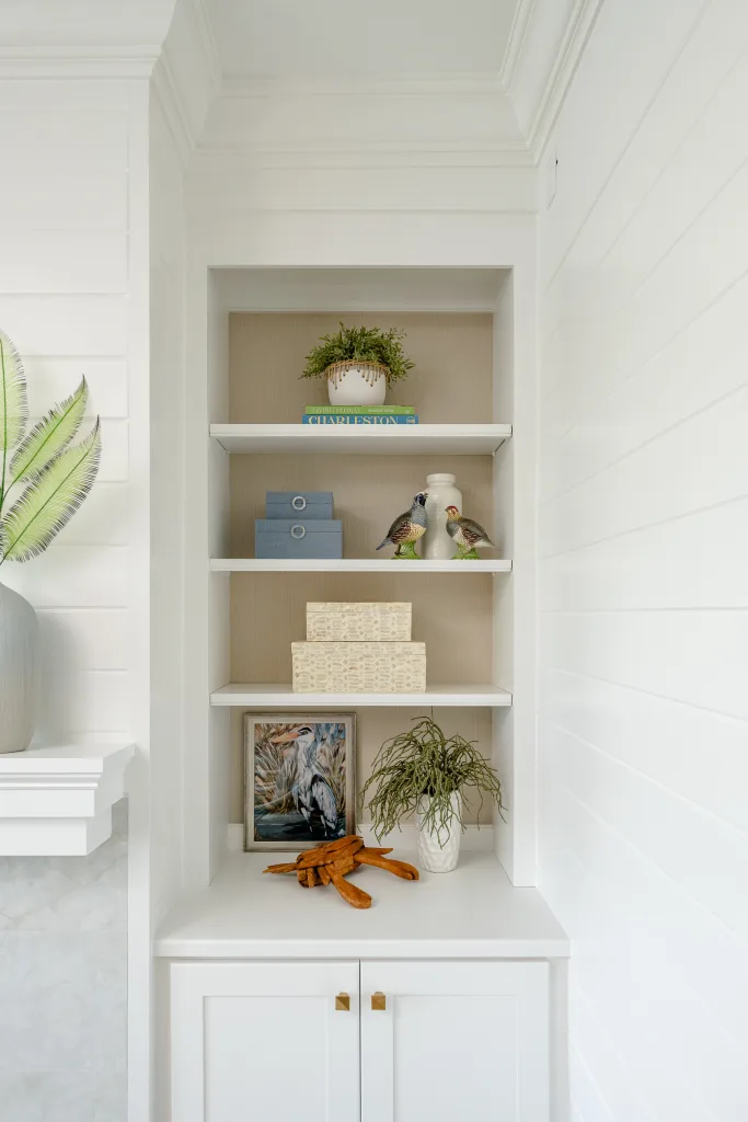 Built-in shelves with grasscloth backing styled with coastal art and ceramic quail, Charleston, SC