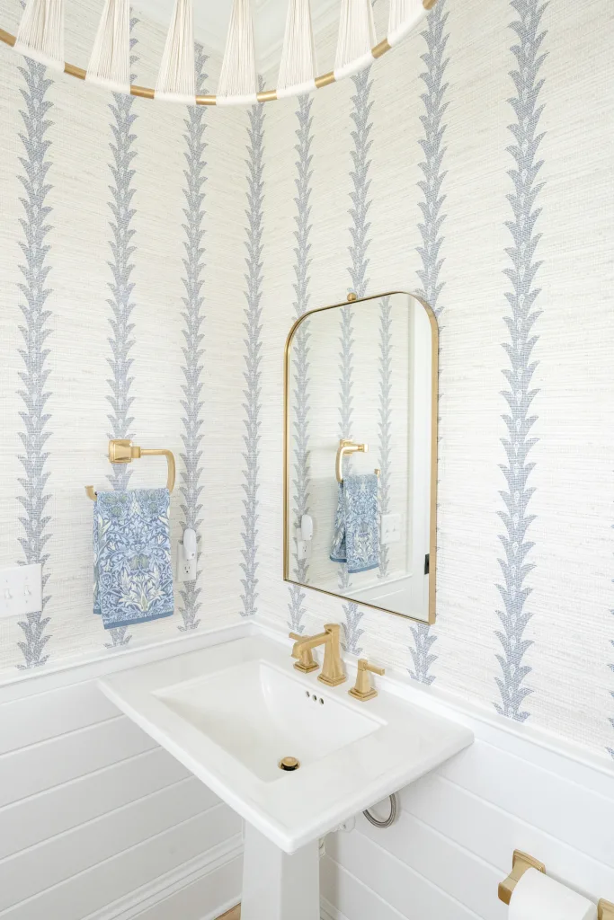 Powder room with botanical striped grasscloth wallpaper and pedestal sink in Charleston, SC