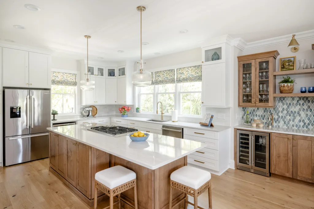 Open-concept kitchen with wood island and patterned Roman shades by Charleston designer Ryan-Marie Preuss