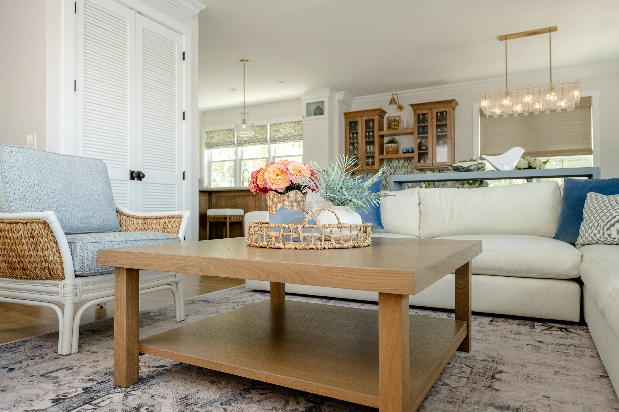 Living room with sectional sofa, rattan chair, and styled coffee table by Charleston designer Ryan-Marie Preuss